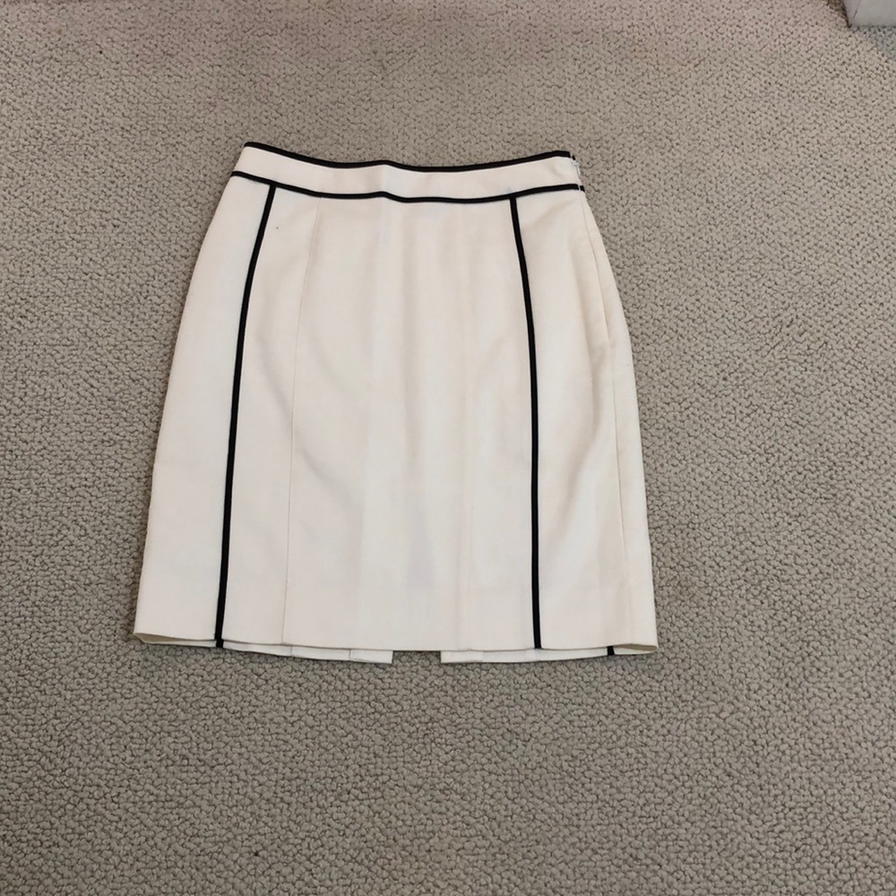 White, knee length skirt with black piping.